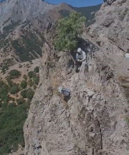 Doğal bal için kayalıklardan sarkıtılan kovanda sağım zamanı